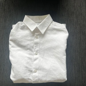 Vit linneskjorta från Selected Homme - Klassisk vit skjorta från Selected Homme i linne. Skjortan har lång ärm, knappar framtill och en stilren krage. Slim fit-modell som ger en snygg och modern siluett. Perfekt festligheter där du har en vit tisha under och uppknäppt översta tre👍🍾