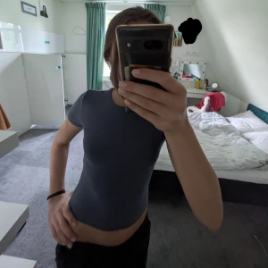 Blå croppad topp - En enkel och stilren blå croppad topp med rund halsringning och korta ärmar. Toppen är figurnära och gjord i mjuk bomull, perfekt att matcha med jeans eller kjol för en clean look.