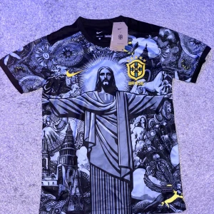 Nike Brasil fotbollströja svart - Unik Brasilien fotbollströja från Nike med Dri-Fit-material. Framsidan har ett detaljerat svartvitt konstmotiv med Kristusstatyn och stadsmotiv, samt gula detaljer och Brasil-logga. Baksidan är helsvart med tryckt emblem upptill. Kortärmad och riktigt snygg design.