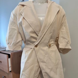 Beige blus        . - Snygg beigemed korta ärmar.    