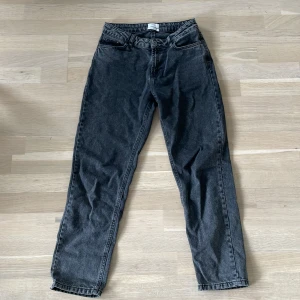 Svarta jeans från Grunt - Snygga svarta jeans från Grunt med hög midja och raka ben. Jeansen har klassisk femficksdesign och är tillverkade i ett mjukt denimtyg. Perfekta till sneakers eller boots för en chill look.