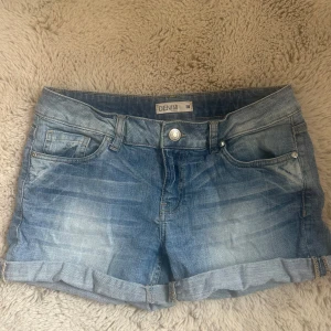 Vintage blå  jeansshorts  - Ett par snygga vintage jeansshorts från Lindex i storlek 38. Köpta secondhand men inga tydliga tecken på användning. 