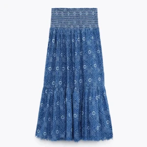 Blå långklänning från Zara - Supersnygg blå långklänning från Zara med vitt mönster och smock upptill. Klänningen har ett bohemiskt mönster och är luftig med volanger nertill. Perfekt för sommarens varma dagar och har en avslappnad passform.