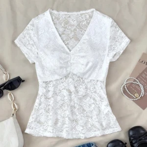 Vit spetsblus med v-ringning - Superfin vit blus i spets med v-ringad hals och korta ärmar. Blusen har ett romantiskt blommönster i spetsen och en lätt rynkning vid bysten. Aldrig använd, bra skönt material
