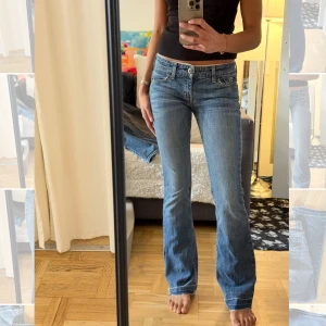 Blå bootcut jeans  - Snygga blå bootcut jeans med klassisk femficksdesign och broderade bakfickor. Jeansen har låg midja och råa, fransiga benslut för en avslappnad vibe. Tillverkade i mjukt denim med lätt tvättad look. Perfekta till sneakers eller boots.