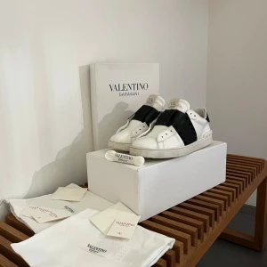 Valentino Garavani sneakers vit/svart - Valentino Garavani Rockstud Untitled sneakers – Str: EU 42, sort kalveskinn  Beskrivelse: Pent brukte Valentino Garavani Rockstud Untitled sneakers i eksklusivt sort kalveskinn. Skoene har noen naturlige bruksmerker og lett innsideslitasje, men fremstår ellers rene og i god stand.  Komplett pakke: 	•	Original skoeske 	•	Tilbehør 	•	To Valentino-logo lærposer til oppbevaring 	•	Helt nye Valentino-lisser klare til bruk  Skoene er ekte, med kvittering og dokumentasjon tilgjengelig ved ønske.   