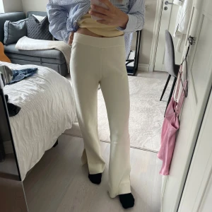 Krämvita byxor från Bianca (nelly)  - Krämvita utsvängda mjukis byxor från Bianca Ingrossos kollektion från Nelly. Säljs pga att de inte används. OBS! Det finns matchande tröja att köpa till (gå in på min profil och kolla) Köp båda delar av settet för 300kr. 