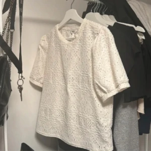 Vit spetsblus  - Säljer en söt vit spetsblus från vero moda. Blusen har korta ärmar och ett vackert spetsmönster som ger en vår känsla. Perfekt för att piffa upp garderoben! 🌸st M men passar er med S också!☺️