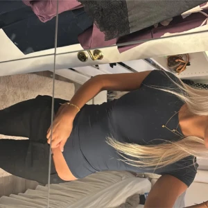 Svart tight t-shirt - Säljer en stilren svart t-shirt med tight passform. Perfekt för en enkel och snygg look. T-shirten har korta ärmar och rund halsringning.