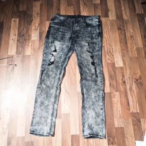 Rare Doomsday Alt Jeans - Säljer ett par grå jeans med coola slitningar på framsidan. Köpt på EMP för 4-5 år sen.