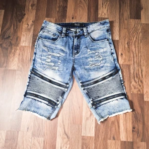 Rare Rock Rebel Jeansshorts - Snygga blå jeansshorts med slitna detaljer och coola dragkedjor över knäna. Köpt på EMP för 5-6 år sen.