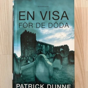 En visa för de döda Patrick Dunne - Inbunden Kriminalroman av Patrick Dunne där arkeologen Illaun Bowe undersöker en mystisk kvinnokropp i en grav. Händelserna utspelar sig i County Meath under december, med en spännande och kuslig atmosfär. 