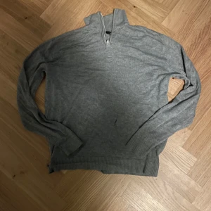 Grå stickad 1/4 zip från lager157 - Säljer en stilren grå tröja från lager157 i otroligt skönt material, är tyvärr fel storlek och säljer därför billigt