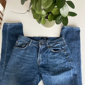 Blå jeans från J.Lindeberg - Snygga blå jeans från J.Lindeberg med klassisk femficksdesign och en bekväm passform. Perfekta för en stilren look. Märkeslapp i läder baktill. Kanske har någon fläck men det går enkelt bort i en tvätt. Riktigt snygga jeans. Storlek 32/32. Hör av dig vid minsta fundering 🤔 pris är ej hugget i sten 🪨 