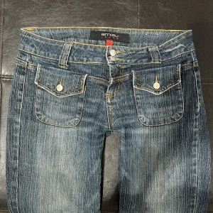jeans - Snygga blå jeans med låg midja och bootcut-stil. De har en klassisk femficksdesign med knappar och dragkedja framtill. 💝💝säljer för att de inte passade mig! 37/38 midjemått 83cm innerben. Passar någon med 36/38. Lägsta pris 300!