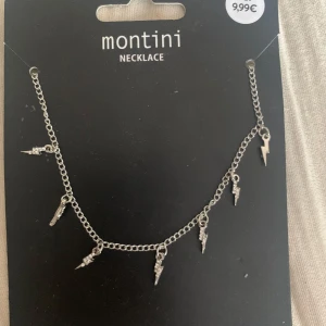 Silverfärgat halsband med blixtberlocker från Montini - Snyggt silverfärgat halsband från Montini med små blixtformade berlocker aldrig andvänd.