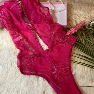 Sexig rosa body storlek medium. - Säljer en sexig rosa body med djup urringning och vackra spetsdetaljer. Perfekt för speciella tillfällen. Den har en öppen rygg och är tillverkad i ett mjukt och elastiskt material för bästa passform.
