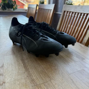 Svarta fotbollsskor med snörning - Snygga svarta fotbollsskor med snörning och diskret mönster. Endast använda en gång så i utmärkt skick. 