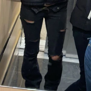 Svarta jeans med hål - Snygga svarta jeans med hål på knäna och lår. De har en tight passform med vida ben, vilket ger en smickrande siluet. Perfekta för en trendig look. Säljer då de inte passar mig längre. Skriv om ni har frågor💕
