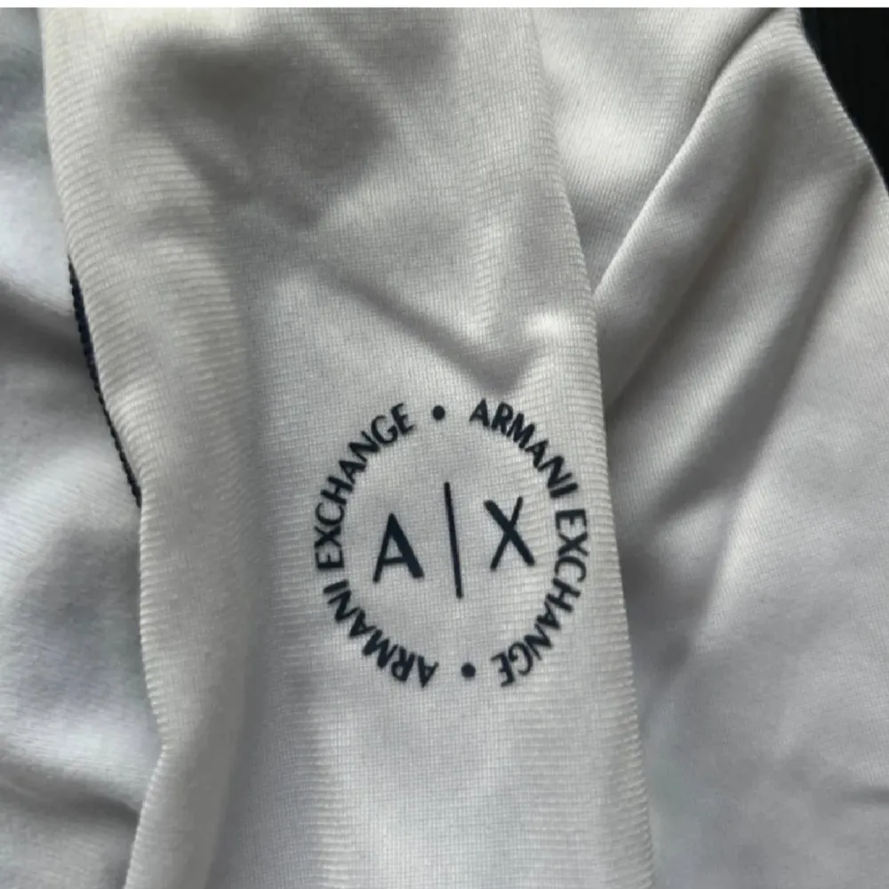 Snygg vit jacka från Armani Exchange med dragkedja och stilrena detaljer. Perfekt för en sportig look. Jackan har långa ärmar och en diskret logga på bröstet.. Neuletakit & Villapaidat.
