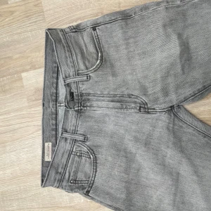 Grå Levis 551 jeans - Säljer dessa skitsnygga gråa jeans från Levis. Jeansen är i modell 551 vilken har passformen regular, storleken är w30 l34. Jeansen är av riktig god kvalité och har därför inga tydliga tecken på användning! Skick 9/10, hör av dig vid minsta fråga eller fundering!