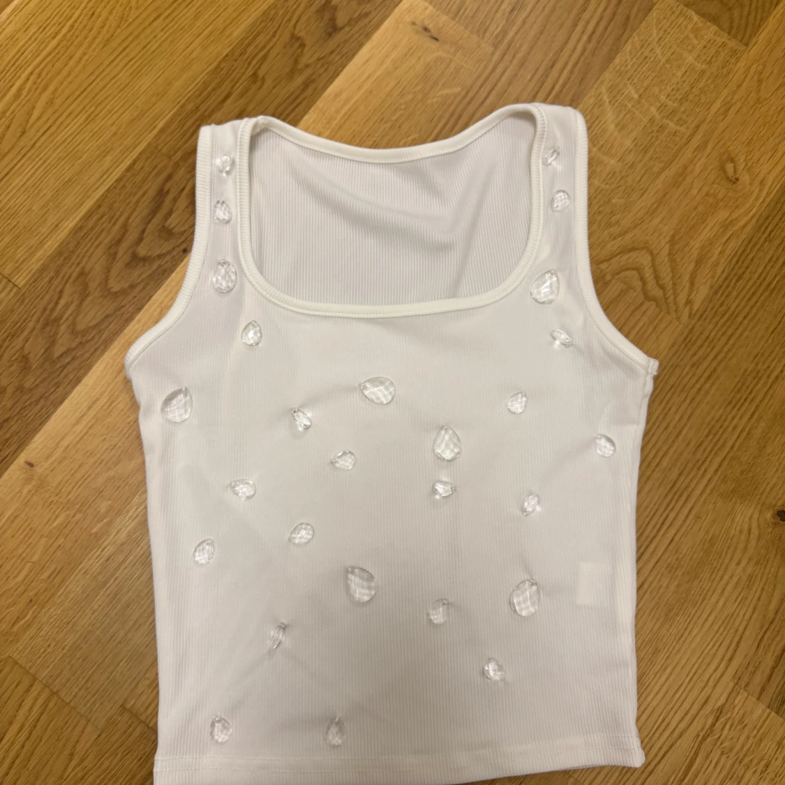 Vit ribbad linnetopp med pärldetaljer