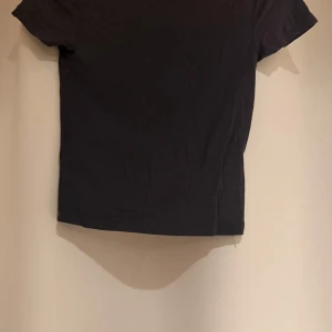 Mörkgrå t-shirt från Gina Tricot XS - En basic mörkgrå t-shirt från Gina Tricot i storlek XS. Modellen är klassisk med rund halsringning och korta ärmar. T-shirten är gjord i mjuk bomull och passar perfekt till jeans eller kjol för en enkel och clean look.