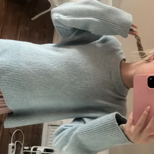 Ljusblå stickad tröja Gina Tricot - Supermysig ljusblå stickad tröja från Gina Tricot med oversized passform. Tröjan har bred ribbad mudd vid ärmslut och nederkant samt rund halsringning. Perfekt för lager-på-lager och chill dagar.