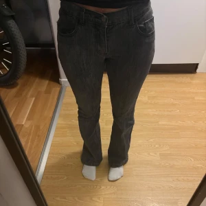 Svarta bootcut jeans från J. Galt - Säljer ett par svarta bootcut jeans från J. Galt med snygg tvättad look och diskreta vertikala ränder. Jeansen har klassisk femficksdesign, normalhög midja och är tillverkade i bomull med lite stretch för skön passform.