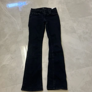 Svarta bootcut jeans från LTB - Snygga svarta jeans från LTB med bootcut-modell. Jeansen har klassisk femficksdesign och är tillverkade i ett stretchigt denimtyg som sitter skönt. Perfekta för dig som gillar en tidlös look med lite utsvängda ben.