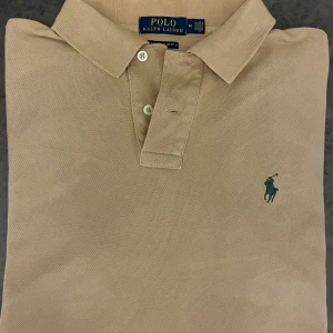 Piké från Ralph Lauren - Snygg beige polo Ralph lauren piké. Mycket bra skick använd cirka 4 gånger. Skriv vid frågor och funderingar.