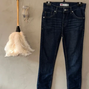 Levi's 510 skinny jeans mörkblå - Mörkblå Levi's 510 skinny jeans med klassiska fem fickor, orange kontrastsöm och röd Levi's-tag på bakfickan. Jeansen har en smal passform och är tillverkade i stretchig denim för extra komfort. Perfekta för dig som gillar en tajt look. Använda 2 gånger. Ordinarie pris 429 kr