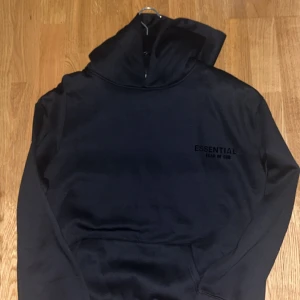 Svart Essentials Fear of God hoodie - Svart hoodie från Essentials Fear of God i storlek M säljs helt oanvänd helt ny.