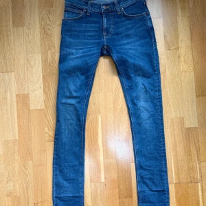 Jeans från Nudie     !HELT OANVÄNDA! - Säljer ett par klassiska blå skinny jeans från Nudie ( modell tight terry). Jeansen har, smal passform och är tillverkade i mjukt denimtyg. Perfekta för dig som gillar en tajt look och vill ha ett par jeans som funkar till allt. Jeansen köptes i fel storlek, storlek 26,32 och därför säljer jag dom. Dom köptes från nudie jeans hemsida för ett par månader sen men har inte orkat lägga upp dom på Plick. Men nu har jag lagt up dom och priset är absolut inte hugget i sten! Kom med förslag! 