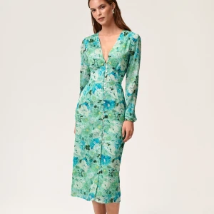 Helt ny Adoore klänning paris strl 36 - Superfin långklänning med grönt och blått blommönster, v-ringning och långa ärmar. Klänningen har knappar framtill och markerad midja för en snygg siluett. Perfekt för dig som gillar romantiska vibes och färg! Helt ny med tags kvar! Storlek 36. Nypris: 1495kr