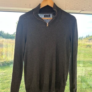 Half zip - Mörkgrå långärmad tröja från Jack & Jones med half zip-dragkedja i halsen. Tröjan har en stilren och enkel design med ribbade muddar och hög krage. Perfekt för lager-på-lager och passar till det mesta. Materialet känns mjukt och bekvämt.