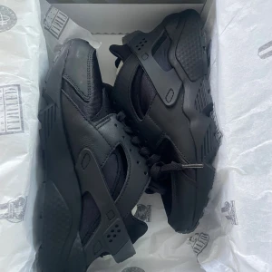 Nike Air Huarache helsvarta sneakers - Säljer ett par helsvarta Nike Air Huarache sneakers i storlek 37.5. Skorna har en chunky sula, klassisk snörning och är tillverkade i en mix av syntet och skinn. Perfekta för dig som gillar en sportig och stilren look. PRIS KAN DISKUTERAS!