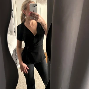 Blus - svart söt blus från Vila med rosett knytning vid sidan och v ringad. Supersöt och skön, nästan aldrig använd