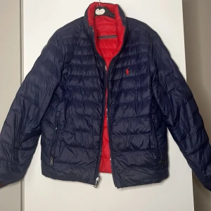Vändbar lättviktsjacka från Polo Ralph Lauren - Säljer en vändbar Polo Ralph lauren jacka. Den ena sidan är blå med röd logga och andra är röd med blå logga. Skick: Mycket bra. Perfekt inför hösten. 