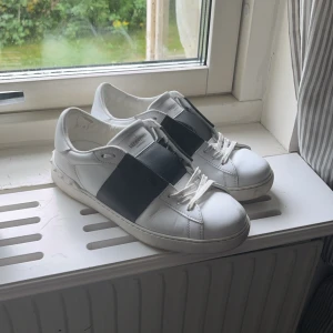 Valentino Garavani Open sneakers vit/svart - Snygga Valentino Garavani Open sneakers i gott skick, dom har lite tecken på användning men inte så man ser de så, (skorna kommer tyvärr inte med box) skorna är 100% äkta , säljer dom för jag ska köpa andra. Dom e 40 men sitter som 41 