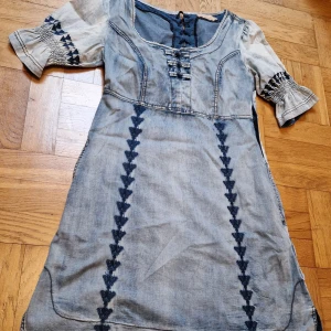 Jeanskkänning från Cream - Jättegullig jeanskkänning med snygga detaljer. Korsettsnörning bak, spets, knappar och broderi. Strl 38 från märket Cream, fint skick. Katt i hemmet.