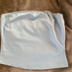 Ljusblå tubtopp från Shein - Säljer en stilren ljusblå tubtopp från Shein. Perfekt för varma dagar eller som ett lager under en jacka. Toppen är elastisk och sitter bekvämt på plats.