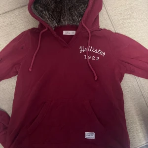 Vinröd hoodie från Hollister - Säljer en mysig vinröd hoodie från Hollister! Stl M, har mysig päls i luvan