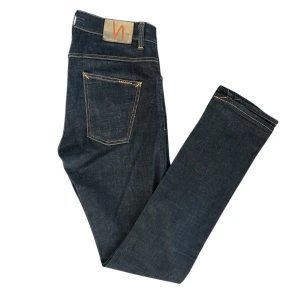 Nudie Jeans Mörkblå - Snygga mörkblå jeans från Nudie Jeans. Slim passform i högkvalitativt denim för en stilren look. Storlek W33 L36, riktigt bra skick. Tveka inte att höra av dig om du har några frågor!