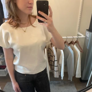 Vit topp med öppen rygg - Säljer en stilren vit topp med båtrigning, korta ärmar och en snygg öppen ryggdetalj. Toppen har en twistad design baktill. Toppen är från Zara och har knappt används. I storlek M, men passar även storlek S. Är öppen för prisförslag, om det finns några funderingar är det bara att skriva till mig💕