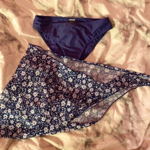Bikini trosa - Blå bikini trosa och en blå blommig bikini kjol man knyter fast på midjan. Stl 160 passar dig som bär på S. Kjolen passar stl Xs och S. Från shein. Använd ett fåtal ggr, kommer aldrig till användning 