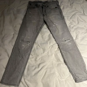 Gråa G-Star RAW Jeans - Snygga grå jeansbyxor från G-Star med slitna detaljer och hål på knäna i storlek 30/34.               Nypris: 1100kr