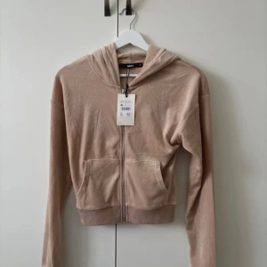 Beige hoodie från Bik Bok - Säljer en beige hoodie från Bik Bok i storlek XS. Den har en dragkedja framtill och en mysig huva. Perfekt för en avslappnad stil. 💛