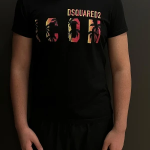 Svart t-shirt från Dsquared2 - Snygg svart ÄKTA t-shirt från Dsquared2 med färgglatt 'ICON'-tryck på bröstet. Tillverkad i 100% bomull för en skön och bekväm känsla. Storlek på t-shirten är L men passar även M. Inget kvitto ingår i med köpet därför kan jag gå ner i pris.