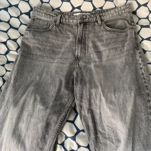 Grå jeans från Bershka - Snygga grå jeans från Bershka i en klassisk femficksmodell. De har en rak passform och är tillverkade i ett slitstarkt denimtyg. Perfekta för en avslappnad stil.